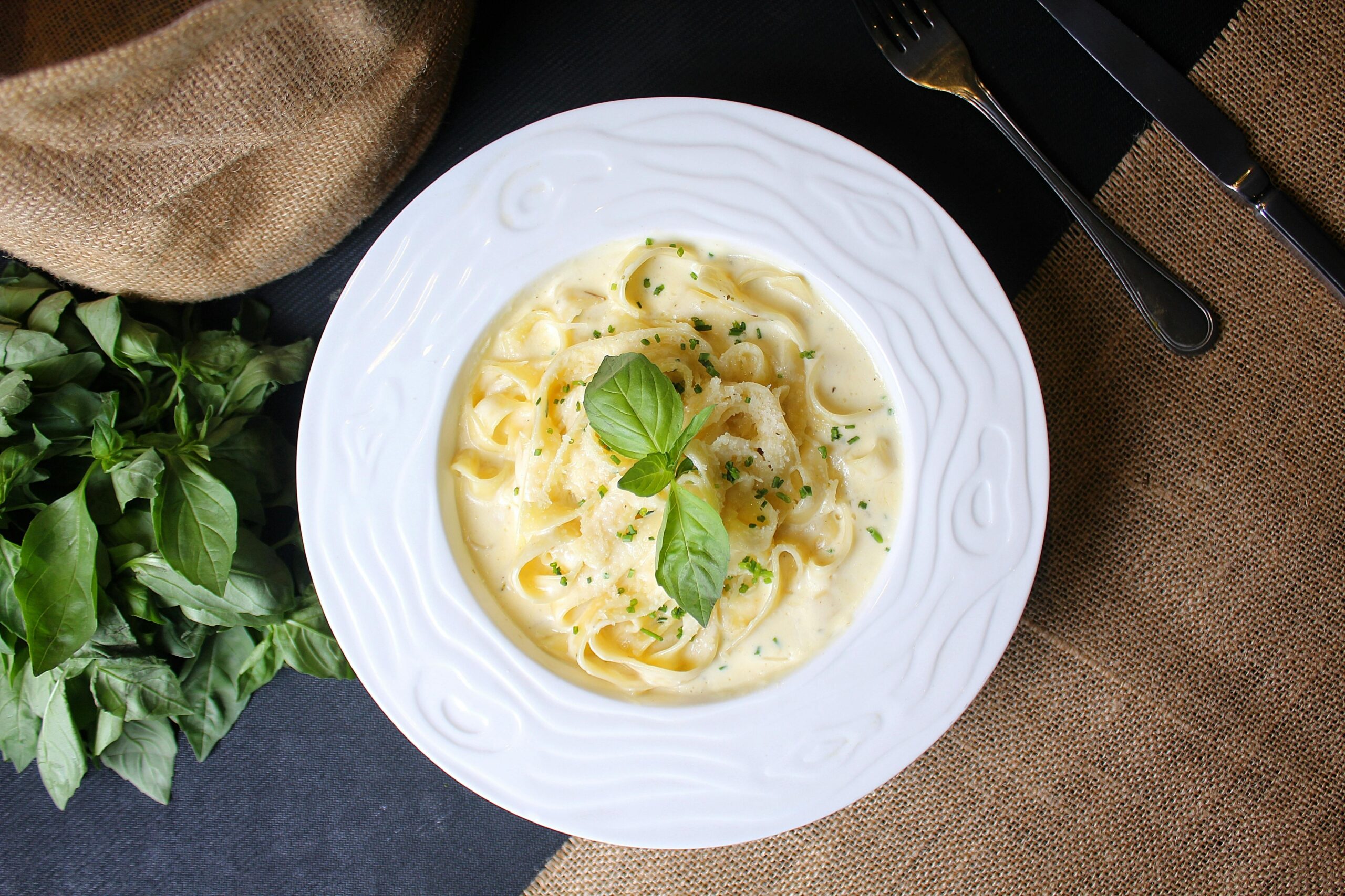 Delicious creamy fettuccine Alfredo with basil garnish, perfect for dinner.